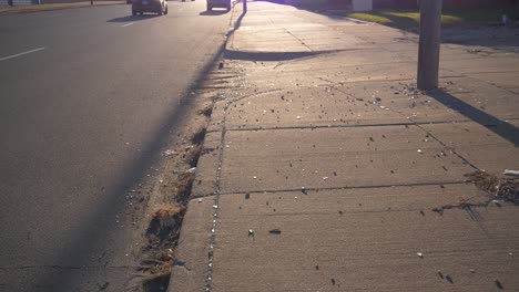 orbiting shot of dirty city curb in detroit with broken glass and debris during the summer