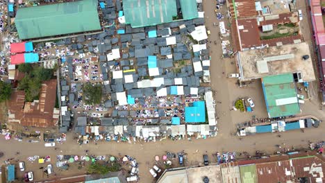 Aerial-view-of-cars-and-people-at-a-Open-Air-Market,-in-Africa---reverse,-drone-shot