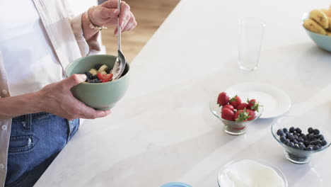 una mujer caucásica de mediana edad disfruta de un desayuno saludable en casa.