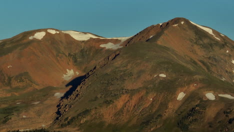 drone cinematográfico aéreo amanecer luz del sol temprano por la mañana sombras grises y torres 14er picos montañas rocosas colorado impresionante vista del paisaje de mediados de verano nieve en la parte superior loveland zoom a la derecha movimiento