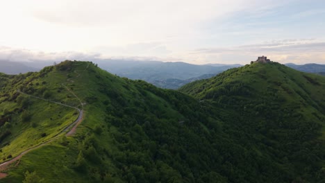ancient hilltop fort in italy surrounded by green hills at golden hour
