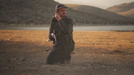 orgulloso tirador disparando un rifle y ajustando los clips de las orejas en el valle de lucerna