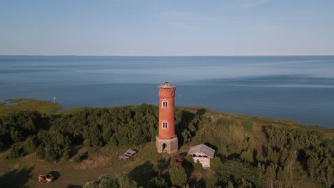 fast flight to window at an old lost place lighthouse - coast of baltic sea - estonia in europe - nature helicopter flyover establishing shot summer 2022 - bird view