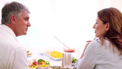 pareja hablando mientras están sentados en la mesa