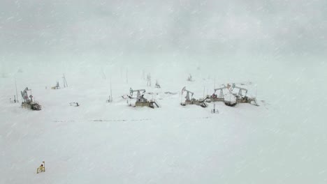 bomba de la industria del petróleo y el gas. trabajo de la bomba de aceite en un campo petrolífero. ártico, polar, norte, oeste, siberia, nevadas, escamas, tormenta de nieve, niebla, humo, aéreo