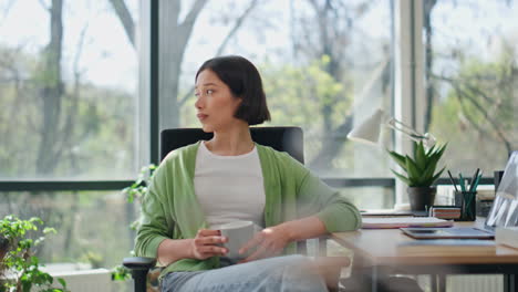 woman taking break drinking coffee in office closeup. dreamy lady sitting