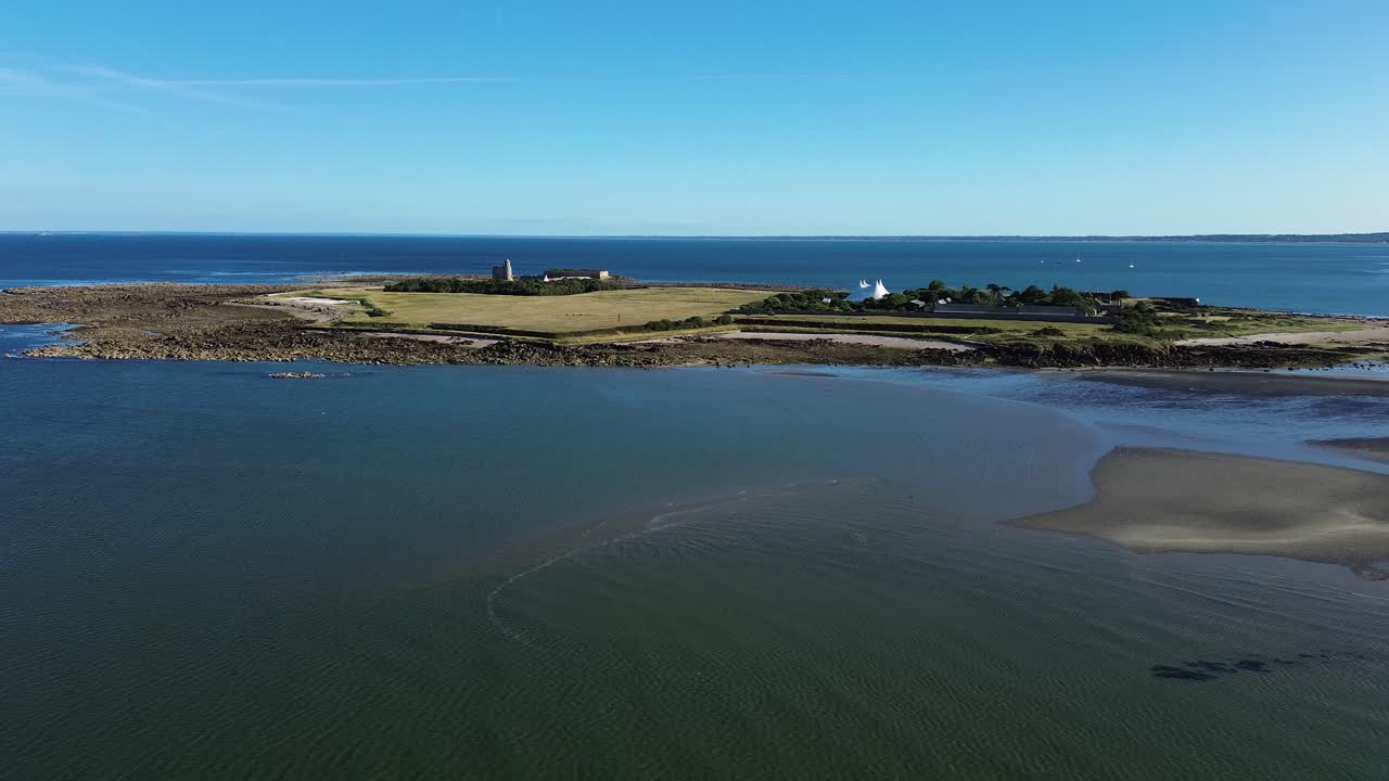Aerial drone footage captures the stunning Tatihou Island in Normandy on a bright sunny day, with its historic fortifications,