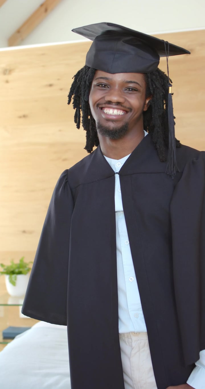 Video verticale: Uomo afroamericano in posa per un ritratto di laurea in soggiorno, con tocco