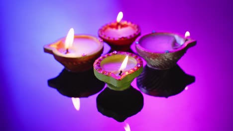 primer plano de las velas coloridas que queman celebrando diwali sobre un fondo púrpura