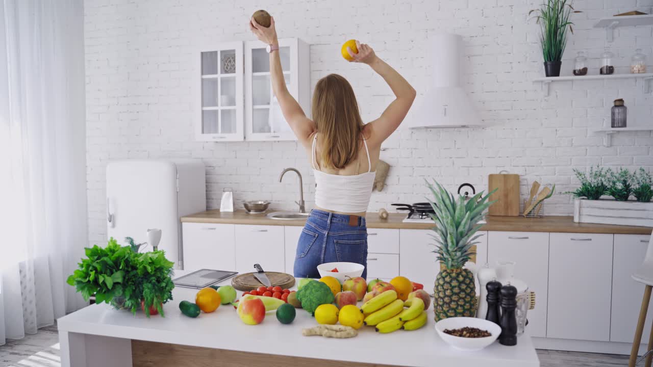 Smiling woman with fruits. Happy smiling woman with fruits having fun in modern kitchen
