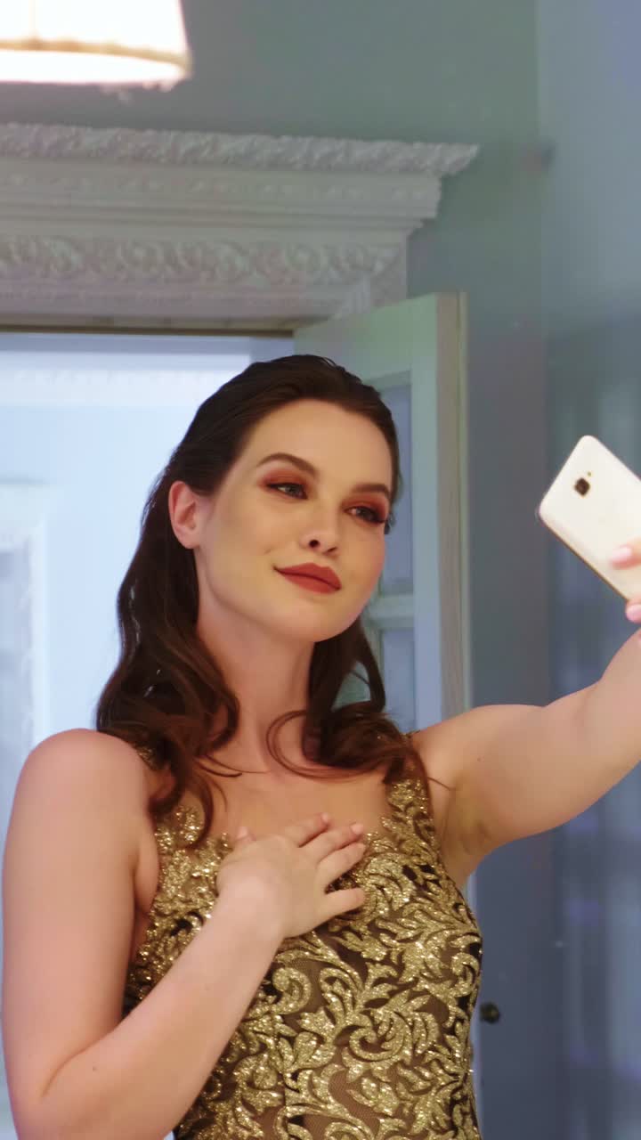 Woman taking a selfie in a gold gown