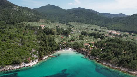 Rotierende-Drohnenansicht-Des-Strandes-Von-Glifoneri,-Mit-Kristallklarem-Wasser-Und-Umgeben-Von-üppiger-Grüner-Vegetation,-Insel-Thassos,-Griechenland,-Europa