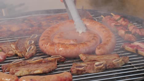 traditional spanish barbeque, big sausage chorizo botifarra, pork and beef ribs on grill with fire, american style cooking, chef grilling meat fat food, steaks and sausages on bbq. high quality 4k footage
