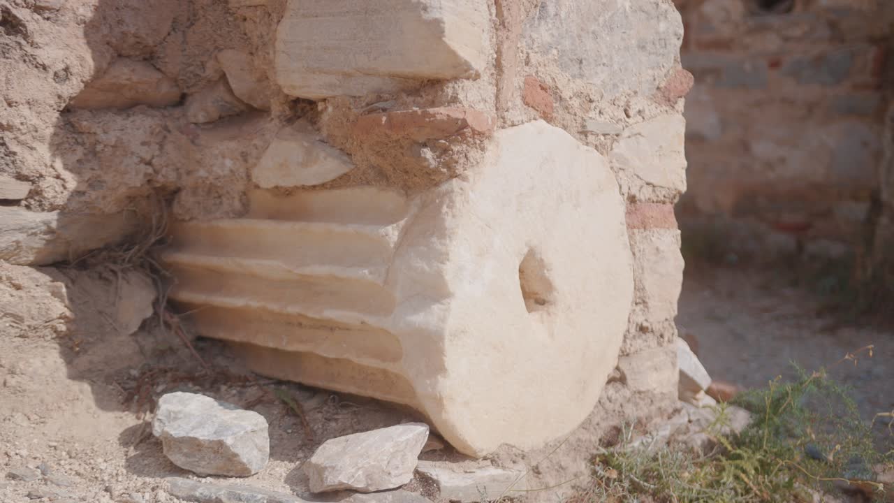 Gamle stenkolonneruiner på et solrigt arkæologisk udendørsområde