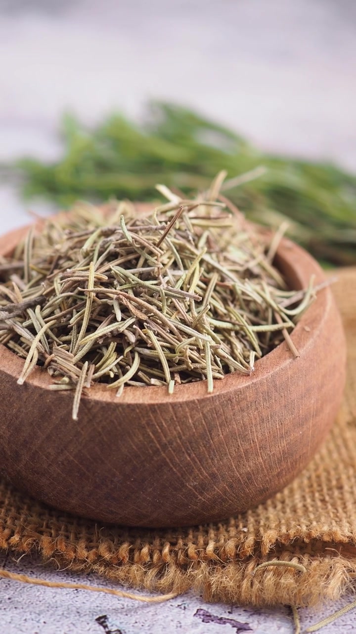 Dried Rosemary Spice in Wooden Bowl with Fresh Herbs