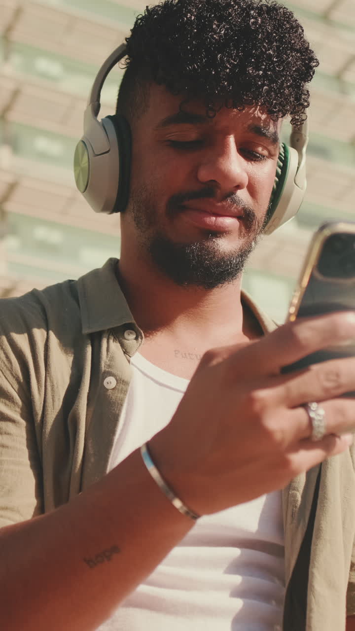 Man with Headphones Using Smartphone Outdoors
