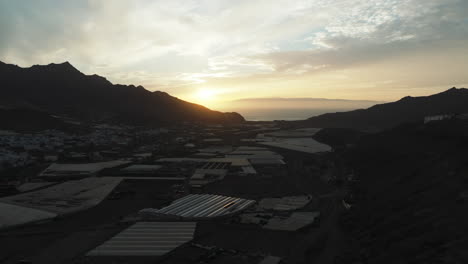 Aerial-view-traveling-in-the-town-of-La-Aldea-during-sunset-and-the-Teide-volcano-in-the-background