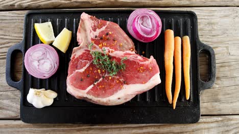 bistec marinado e ingredientes en la bandeja de la parrilla