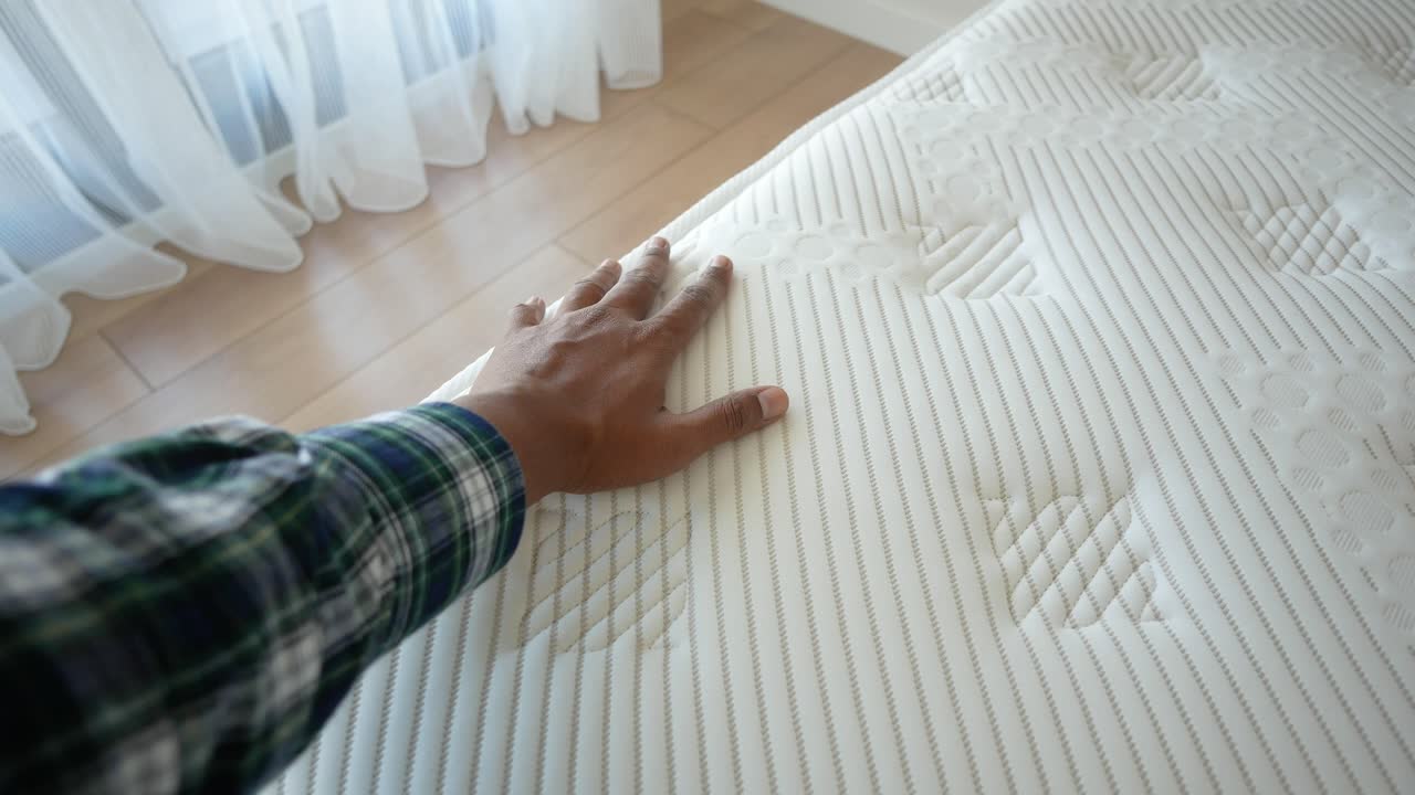 la mano de una persona tocando un colchón
