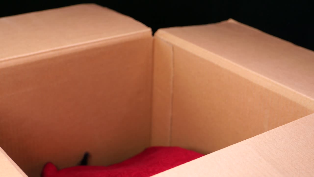 종이 상자 에 옷 을 넣고 있는 것