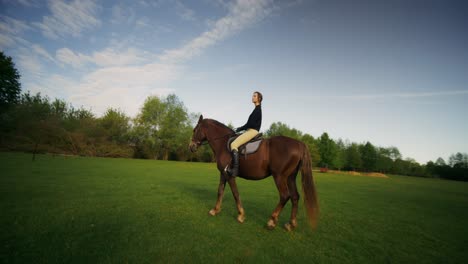 woman horseback riding in a field