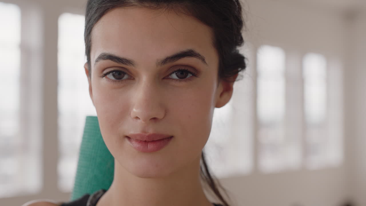 retrato atractivo mujer de yoga sonriendo con confianza mujer caucásica disfrutando de un estilo de vida saludable con gente practicando en el fondo del gimnasio