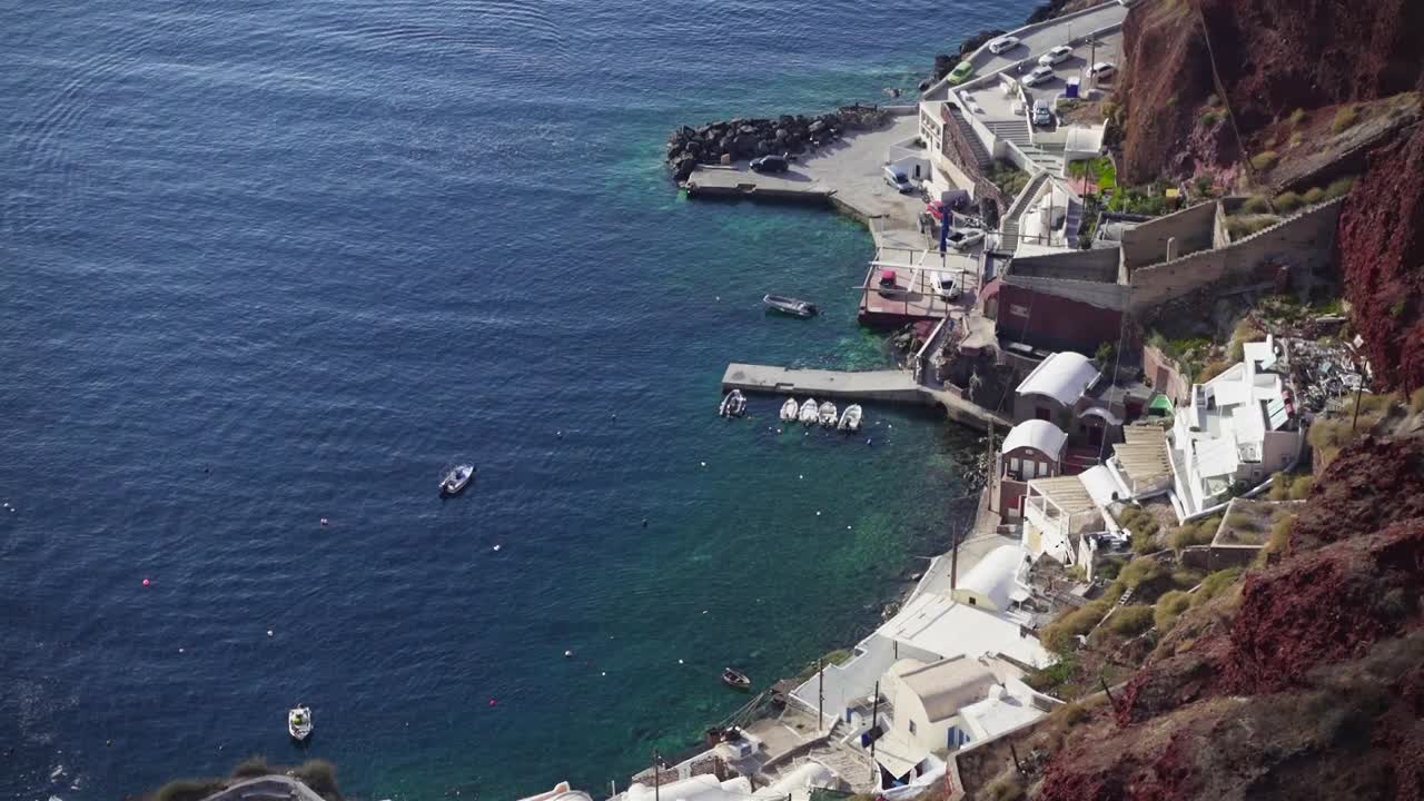 vista desde arriba a un pequeño muelle con barcos en el mar egeo, santorini, grecia