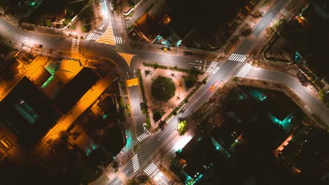 aerial time lapse of a triangle-shaped intersection where vehicles pass leaving a trail of light at night