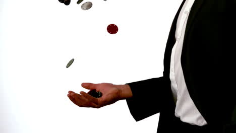 man in suit throwing and catching casino chips