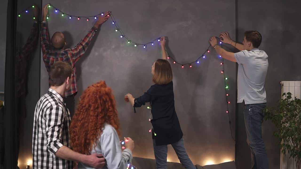 grupo de amigos más cercanos decorando la habitación con luces 1