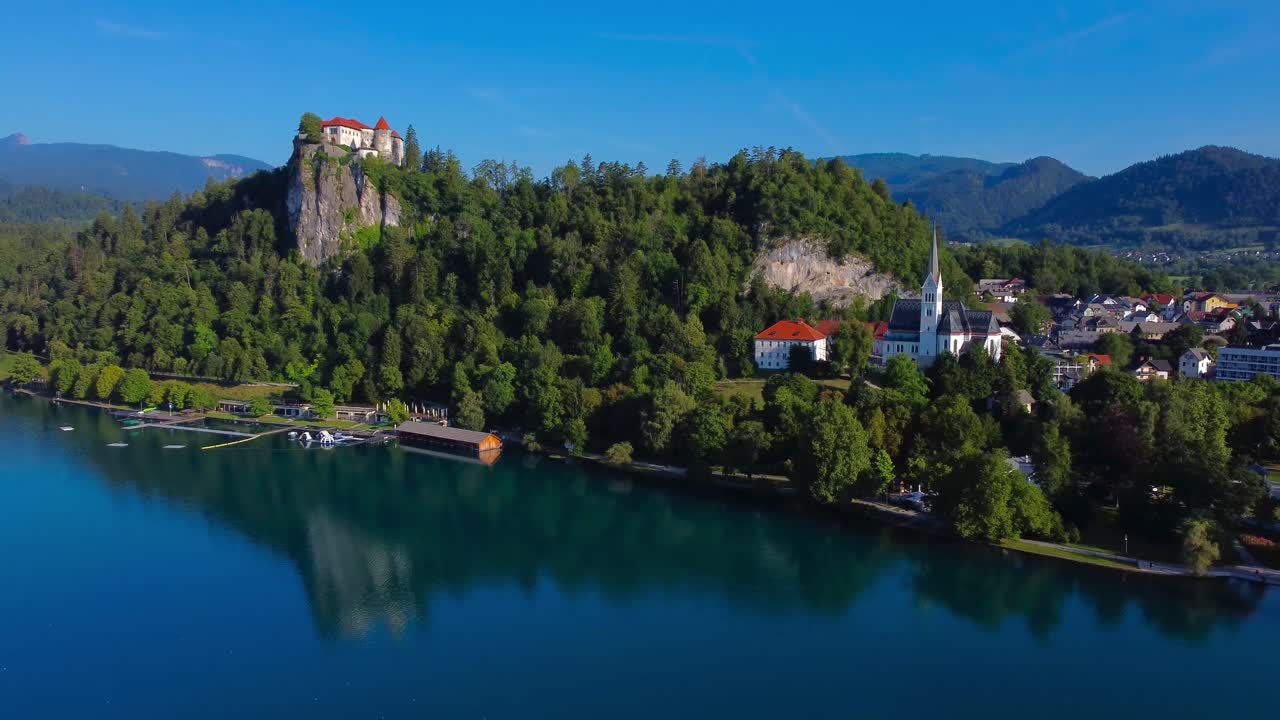 Aerial 4K drone video of Bled Town and Bled Castle on a clear sunny summer's morning - Lake Bled, Slovenia