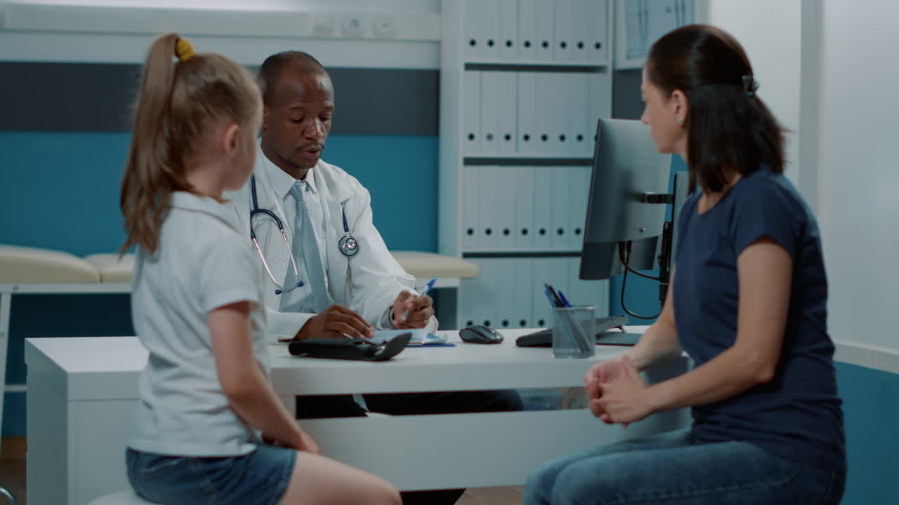 Doctor Consulting with Child Patient and Mother in Clinic