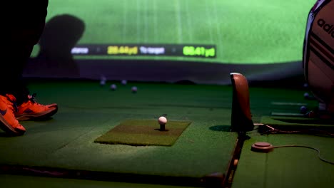 golfer practicing swings at an indoor range