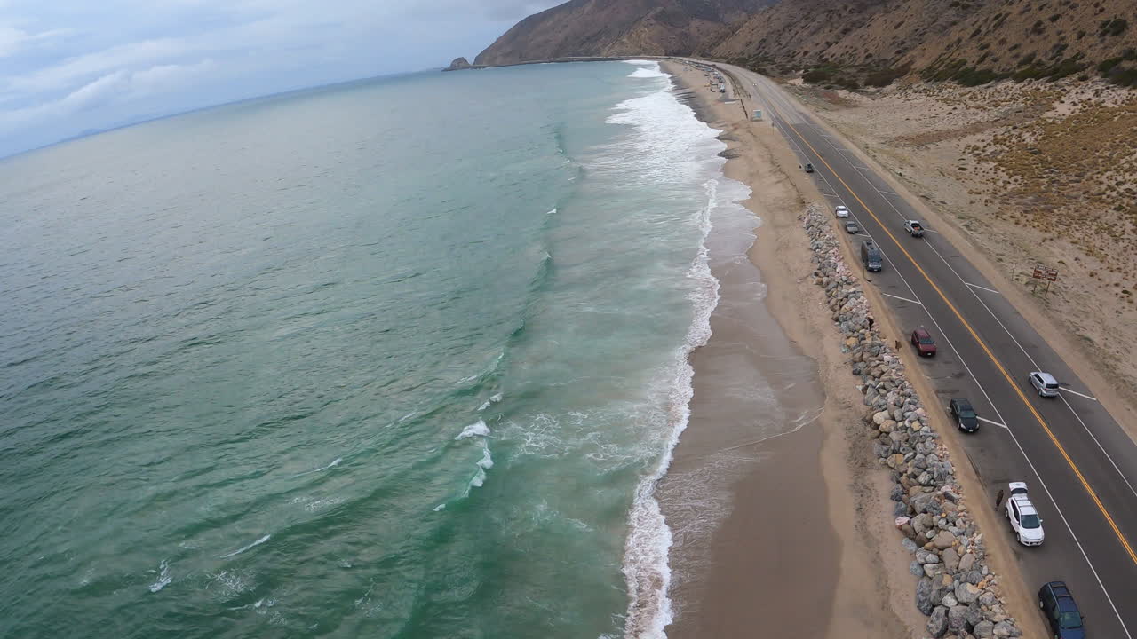 disparos de drones sobre la carretera de la costa del pacífico, rompiendo las olas del océano y montañas majestuosas
