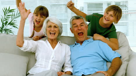 Abuelos-Y-Niños-Levantando-Los-Brazos-En-El-Salón