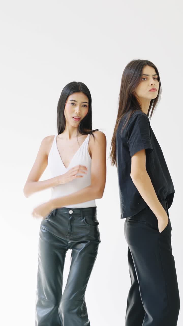 Two women posing in black and white outfits