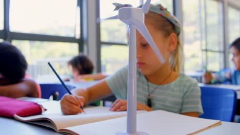 colegiala caucásica estudiando en el escritorio en el aula 4k