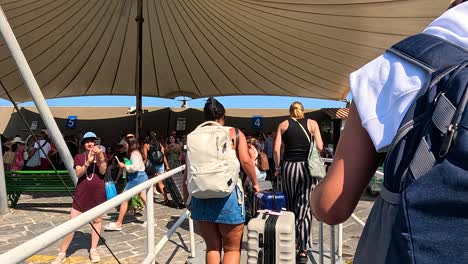 tourists queue to board a ferry in sorrento