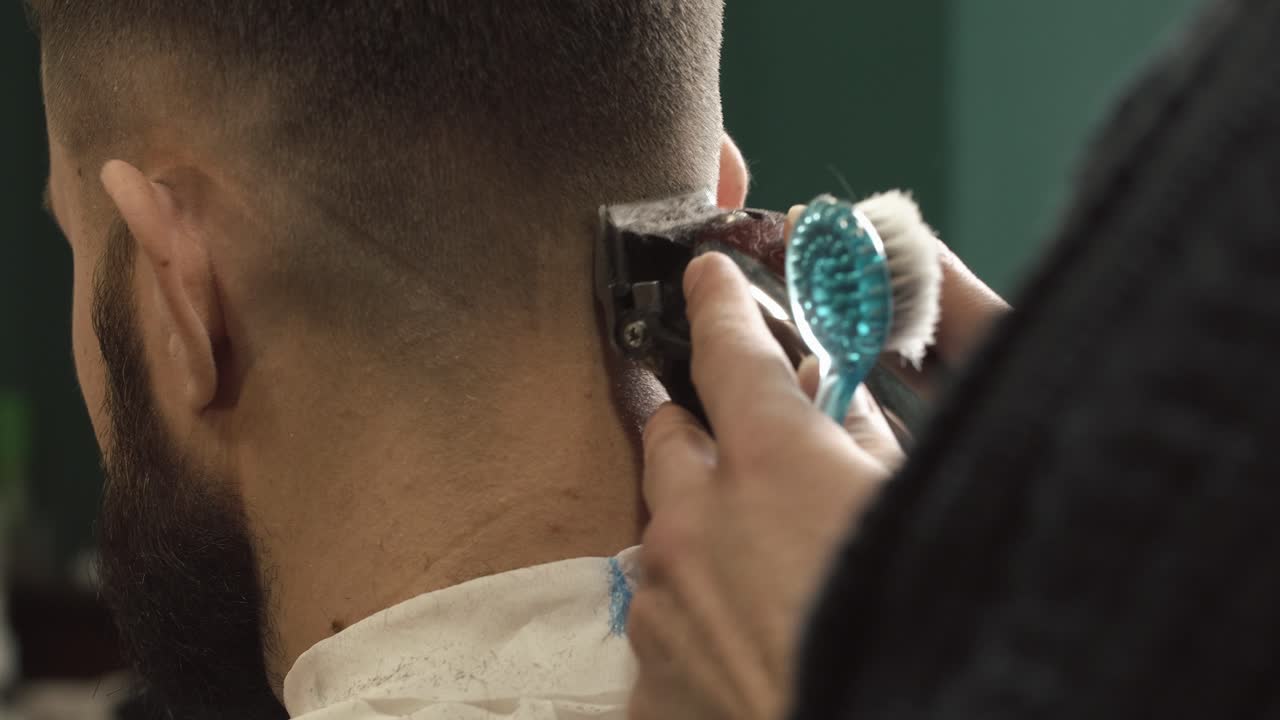 Professional Barber Trimming a Client's Hair with Clippers