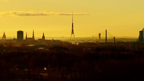 drone moves sideways showing riga’s skyline silhouettes glowing in sunrise haze