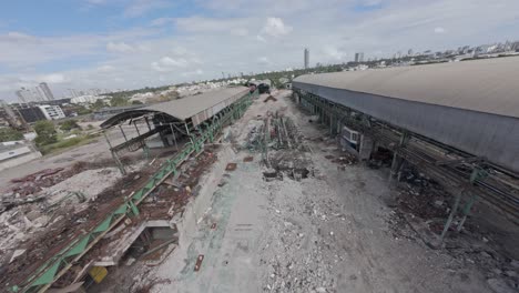 ruins of old abandoned metal factory building in malecon, santo domingo, dominican republic. fpv drone shot