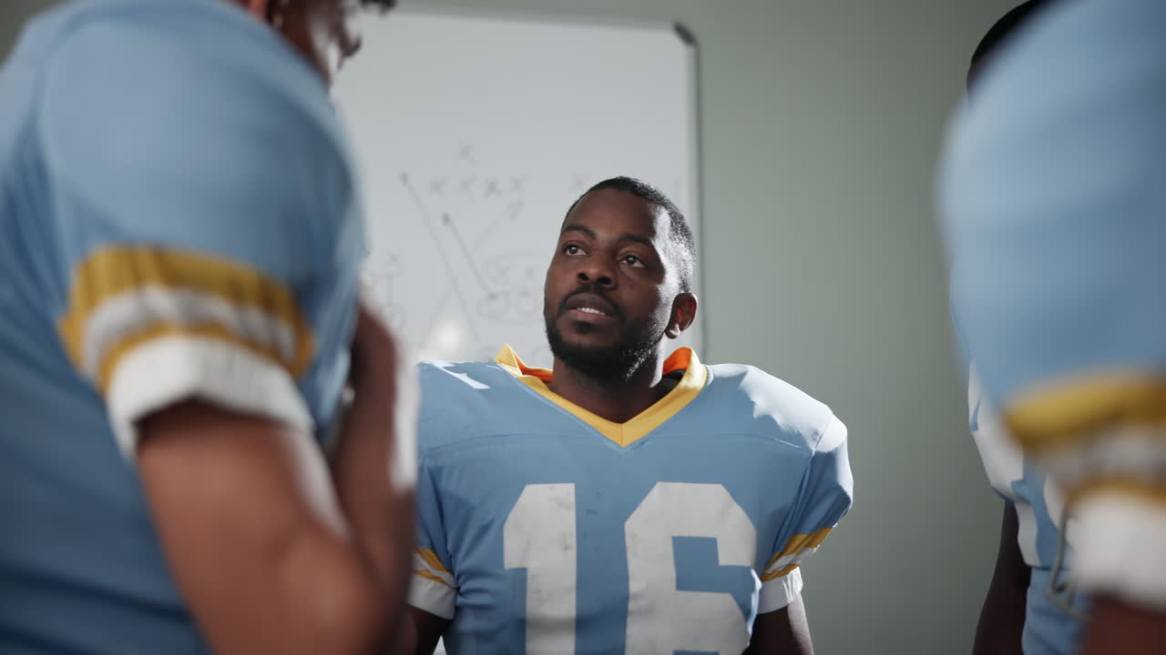 Football team strategizing in locker room