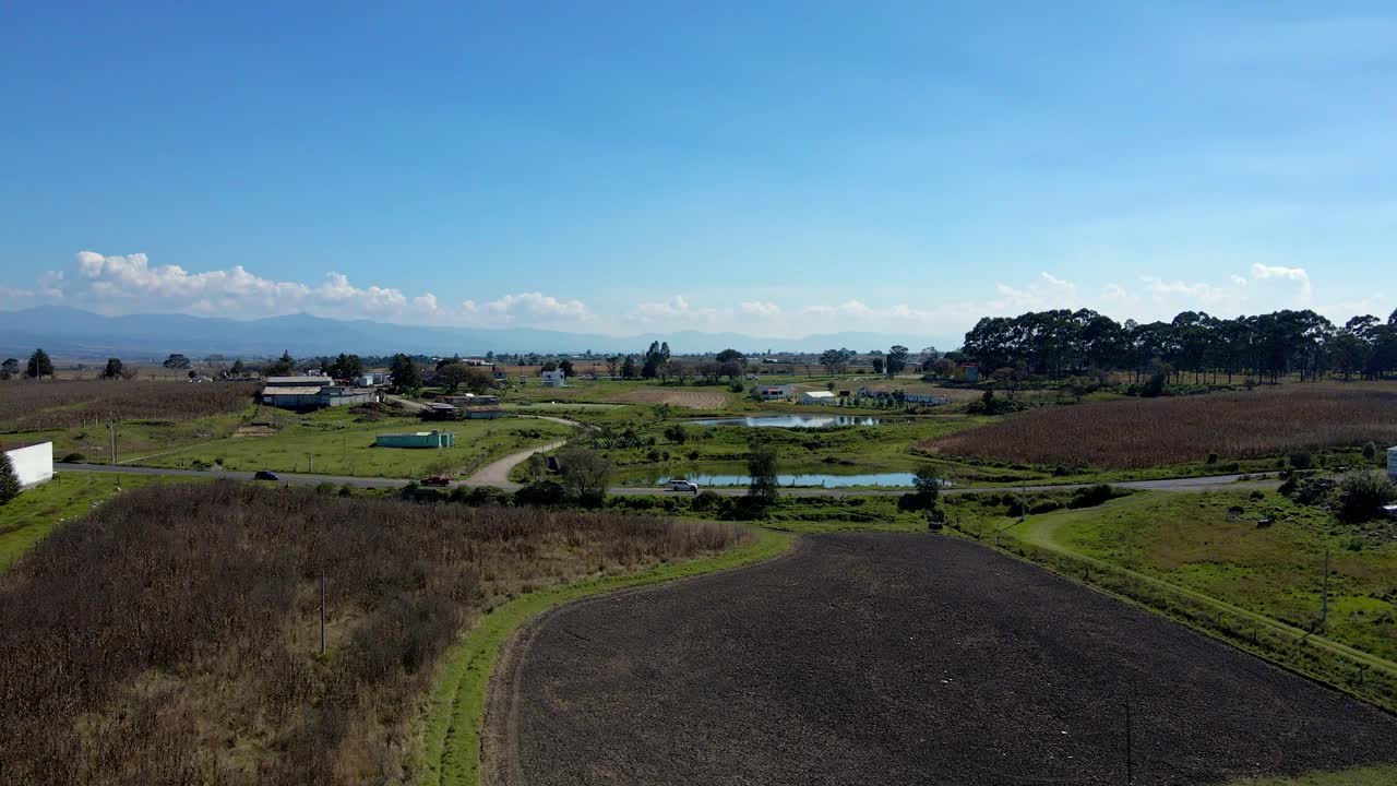 Bird's eye view over vast fields of farms, field rooted by fire on a sunny day, drought