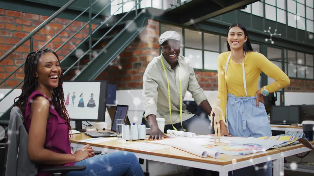 Designers collaborating around table in fashion loft, showing animated measuring tape and sketches