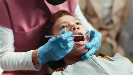 a young boy getting a dental check-up by a dentist