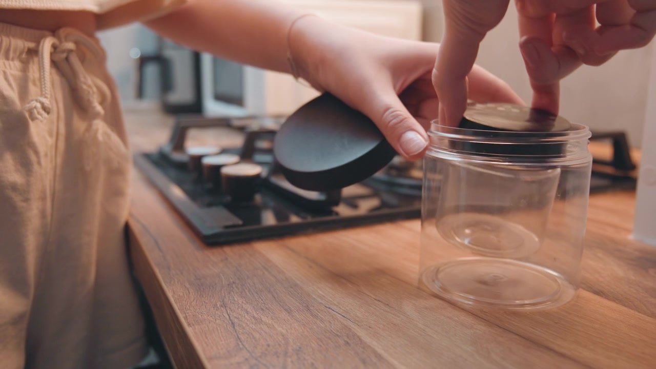 Clean jar on wooden counter. Elegant kitchen environment with neatly arranged jars and stove background. Idyllic culinary space showcasing tidy storage and warm ambient lighting in kitchen