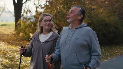 caucasian senior couple nordic walking in the park.