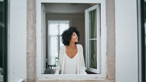 Chica-De-Pelo-Negro-Agitando-La-Ventana-Por-La-Mañana-Casa.-Mujer-Sonriente-Rizada-Asomando-Afuera