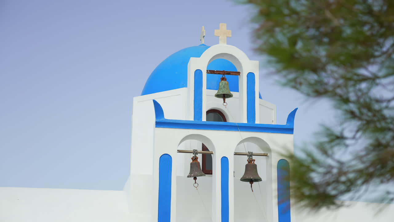 tres campanas de la iglesia cuelgan en una impresionante iglesia griega blanca y azul en santorini