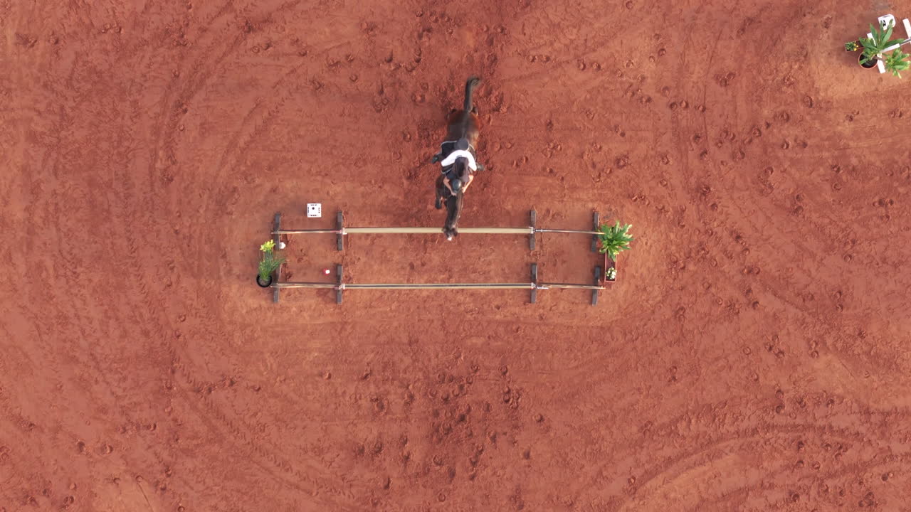 Aerial top view of rider jumping on horseback in Olympic equestrian competition